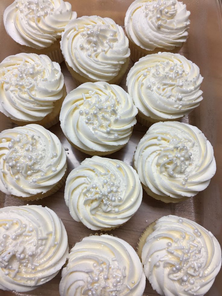 cupcakes with white frosting in a glass dish