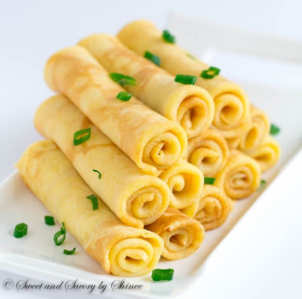 several rolled up food items sitting on a white plate with green garnishes