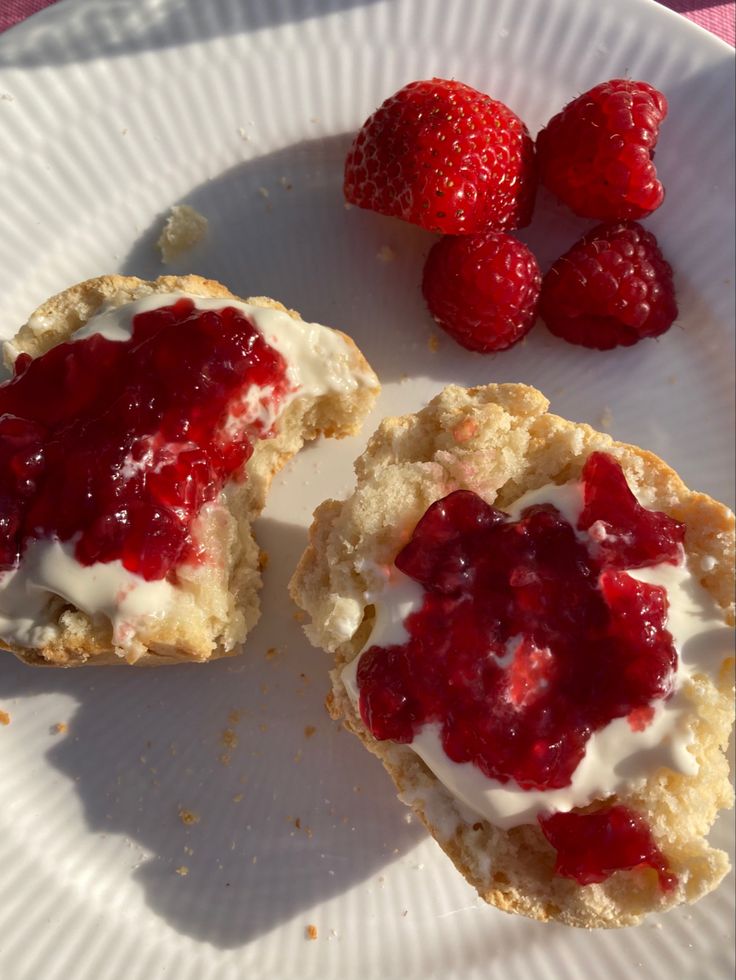 raspberry and cream muffins on a paper plate with fresh strawberries