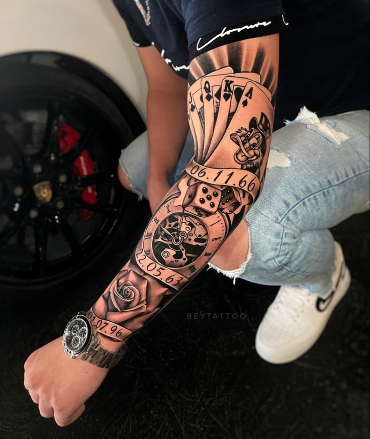 a man with a tattoo on his arm is sitting in front of a tire wheel