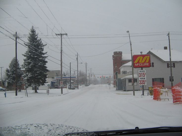 there is a mcdonald's sign on the side of the road covered in snow