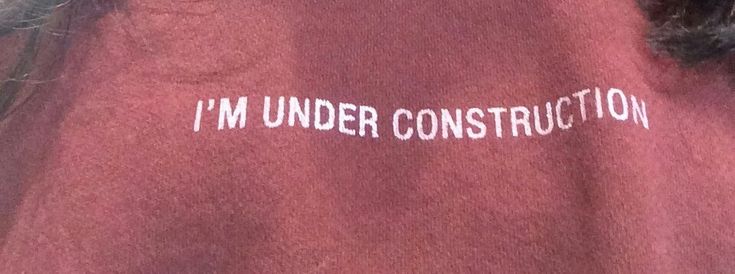 i'm under construction written on the back of a red shirt with white writing