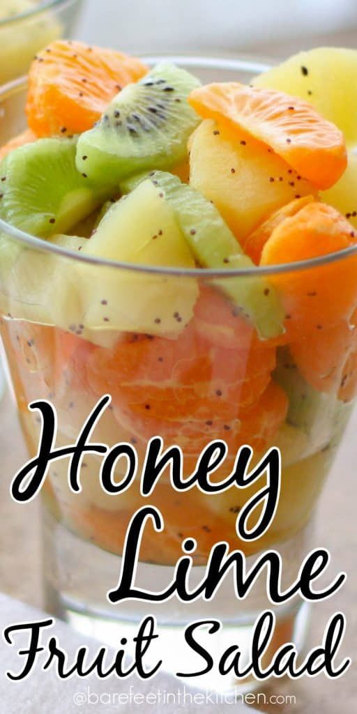 a glass bowl filled with fruit salad and the words honey lime christmas fruit salad