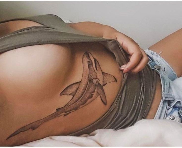 a woman with a shark tattoo on her stomach