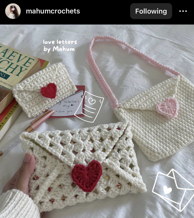 crocheted purses and envelopes are laying on a bed with love letters