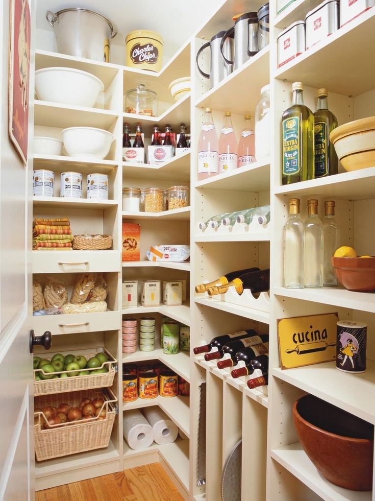 an organized pantry with white shelving and lots of food on the shelves, along with baskets