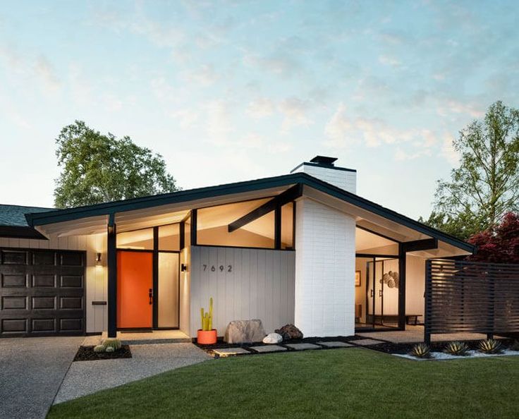 a modern house with an orange front door