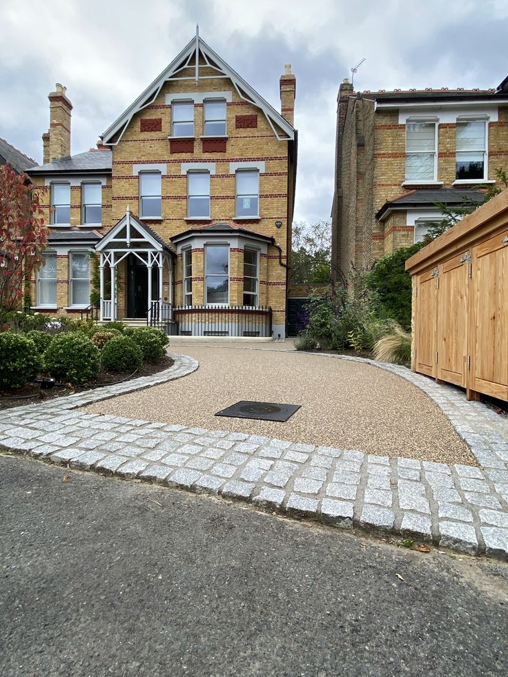 a large brick driveway in front of a two story house