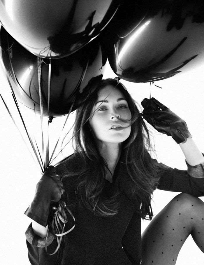 black and white photograph of a woman holding balloons