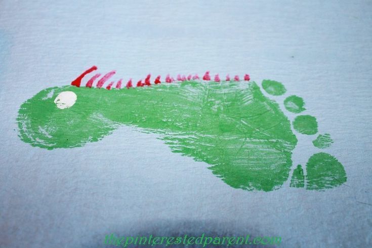 a child's hand and foot print on a t - shirt that is green