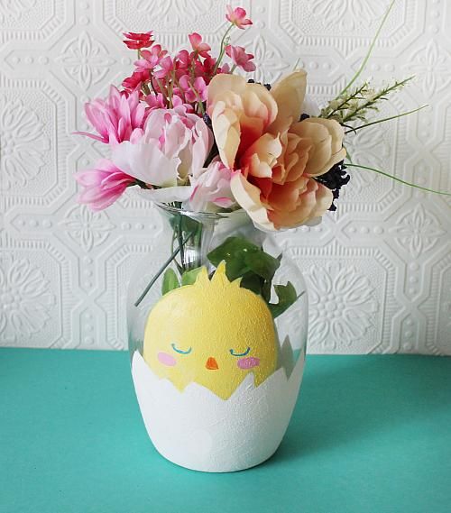 a vase filled with flowers on top of a blue table next to a white wall