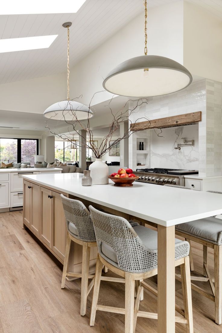 a large kitchen with an island in the middle and chairs at the counter top on both sides