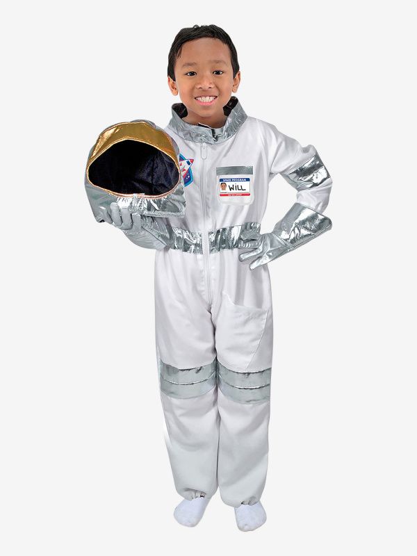 a young boy dressed in an astronaut suit and helmet with his hands on his hips