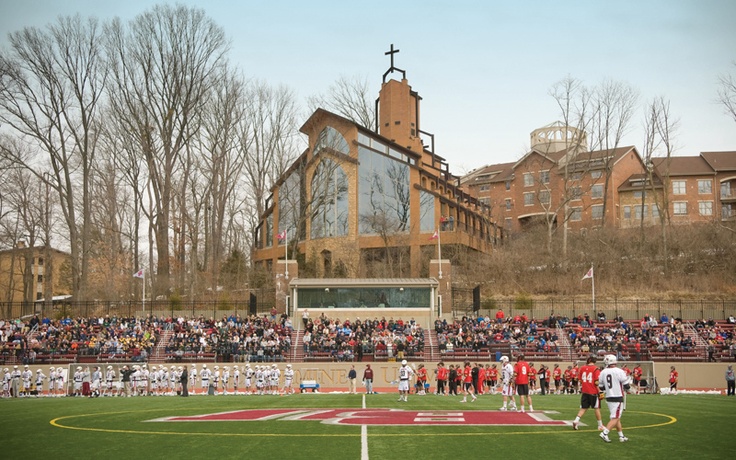 a group of people standing on top of a field next to a soccer ball court