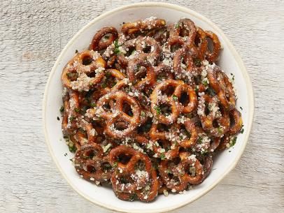 a bowl filled with lots of pretzels covered in powdered sugar and sprinkles