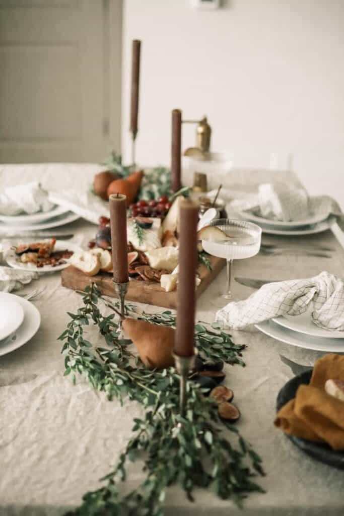 the table is set with candles, plates and napkins for an elegant thanksgiving dinner