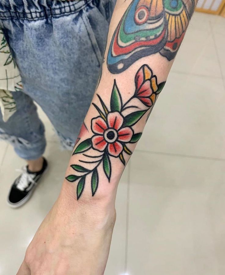 a person with a colorful tattoo on their arm and the other hand is holding an object