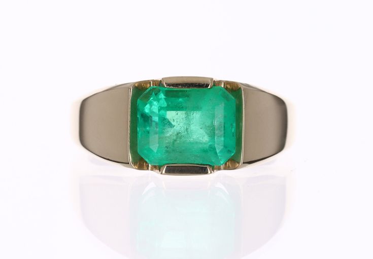 Displayed is a classic and unique Colombian emerald solitaire emerald cut men's ring in 14K yellow gold. This solitaire ring carries a full 3.52-carat emerald in a secure tension prong setting. The emerald has very good clarity with minor flaws that are normal in all genuine emeralds. The gem has a medium-rich green color and a very good luster. An ideal solitaire, perfect for everyday use! Setting Style: Tension - Solitaire Setting Material: 14K Yellow Gold Weight: 8.4grams Main Stone: Emerald Formal Octagon Solitaire Emerald Ring, Classic Emerald Signet Ring For Formal Occasions, Classic Emerald Signet Ring For Formal Events, Modern Octagon Emerald Ring For Formal Occasions, Modern Emerald Signet Ring For Formal Occasions, Timeless Emerald Signet Ring For Formal Occasions, Modern Emerald Cut Emerald Signet Ring, Rectangular Solitaire Emerald Ring For Formal Occasions, Formal Emerald Signet Ring With Prong Setting