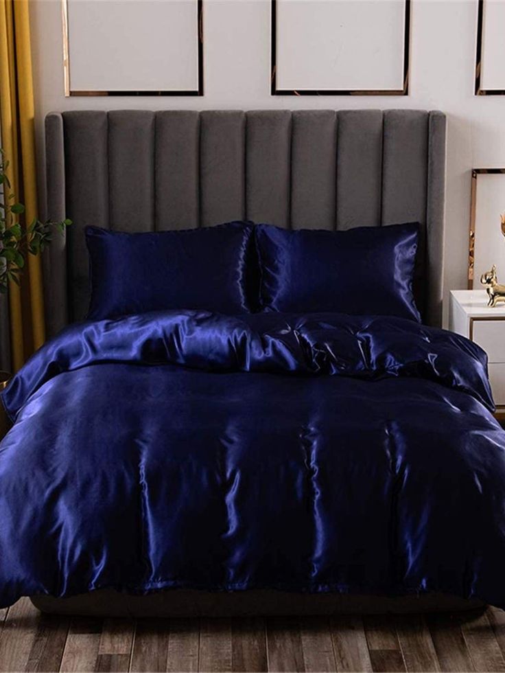 a bed with blue sheets and pillows in a room