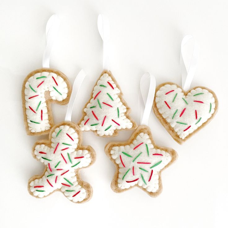 four decorated cookies in the shape of christmas trees