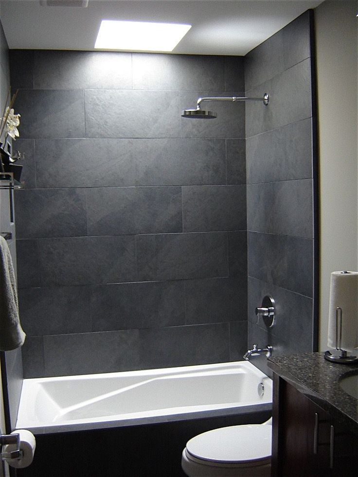 a white toilet sitting next to a bath tub in a bathroom under a skylight