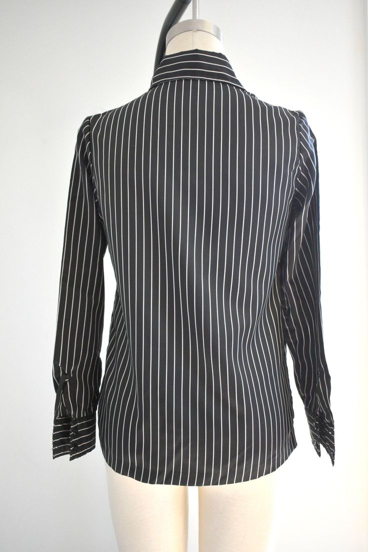 "Description: 1970s black and white striped silky polyester blouse. Long sleeves with pleated shoulders. Button front. Condition: In great condition, with no holes or stains. Designer: It's Gailord Stated Size: 10 Measurements: Armpit to armpit: 18\" Shoulder to shoulder: 14.5\" Sleeve length: 23\" Overall length: 23\" Waist: up to 35\" ---> If you need an order shipped by a particular date or shipped via a quicker method, please ask PRIOR to purchase to see if we can accommodate that request Elegant Pinstripe Button-up Blouse, Long Sleeve Blouse With Vertical Stripes For Office, Classic Black Shirt With Vertical Stripes, Striped Button-up Blouse For Office, Black Formal Top With Striped Collar, Elegant Pinstripe Tops With Button Closure, Striped Button Blouse For Work, Classic Formal Blouse With Striped Collar, Elegant Vertical Striped Workwear Blouse