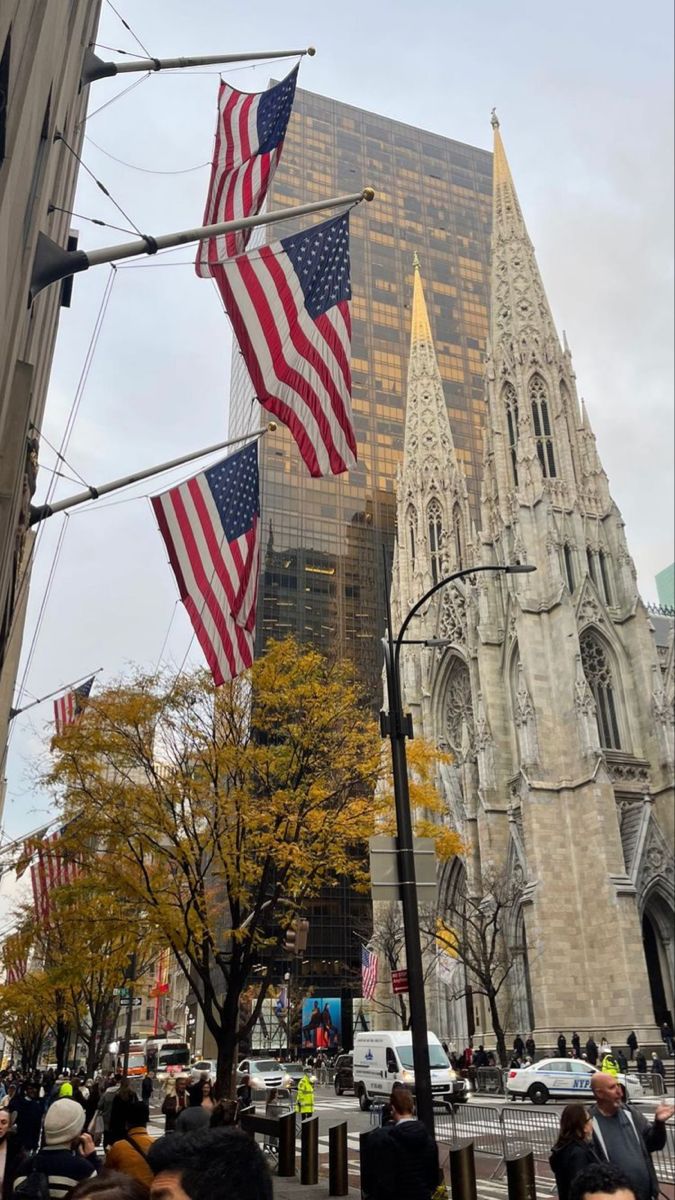 several american flags are flying in front of the cathedral