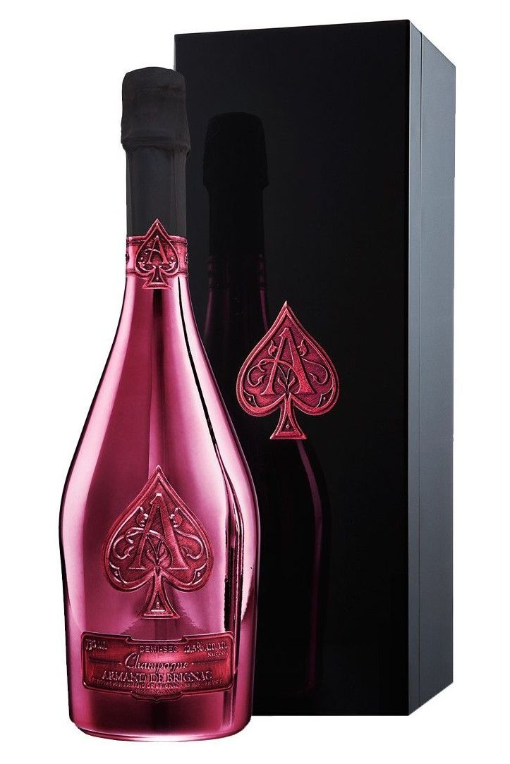 a bottle of pink wine next to a black box with playing cards on the side