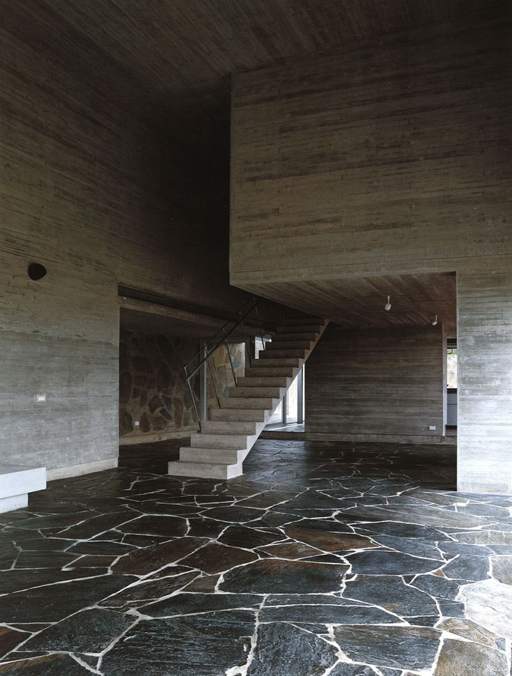 an empty room with stone floors and stairs