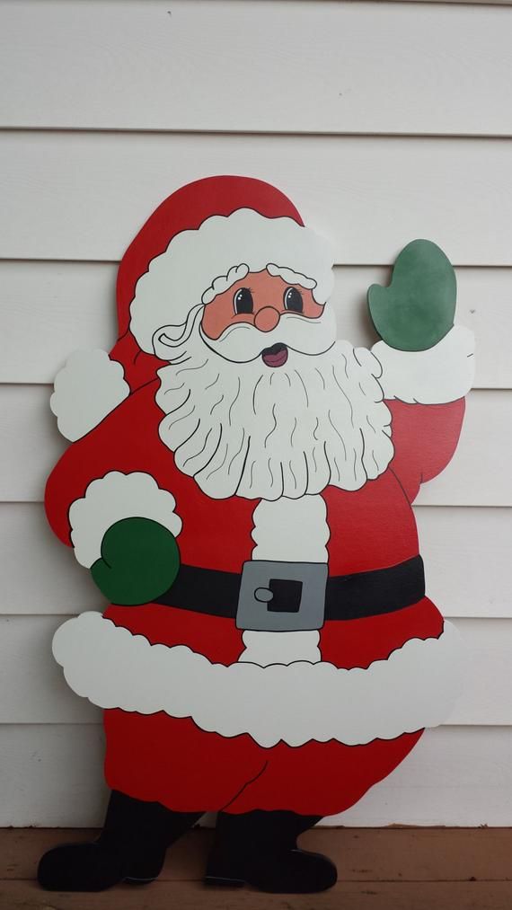 a cardboard santa clause standing in front of a white wall