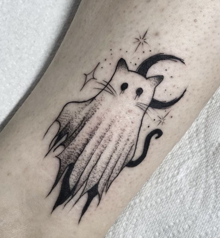 a black and white cat tattoo on the leg, with stars in the sky above it