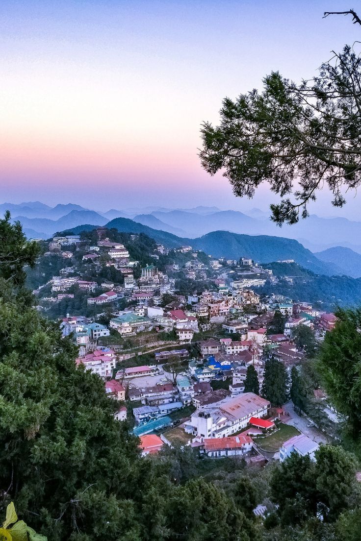 the city is surrounded by trees and mountains in the distance, as seen from above