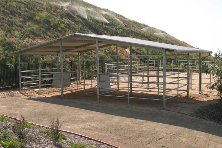 a metal shelter on the side of a dirt road