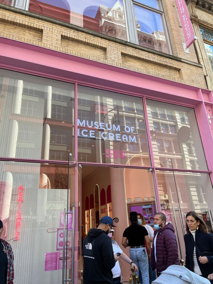 people are standing outside the museum of ice cream in front of a pink storefront