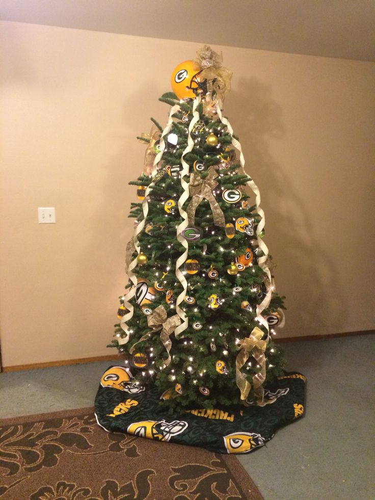 a decorated christmas tree in the corner of a room with a football theme on it