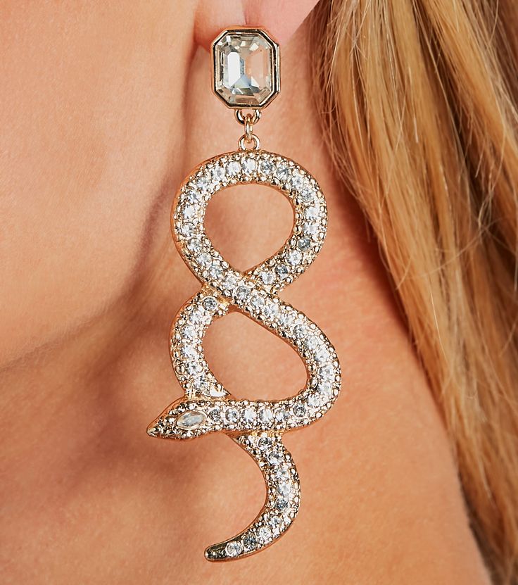 Get ready to be dangerously glam in these earrings! Featuring clear rhinestone studs and intertwining snakes embellished with sparkly rhinestones, these earrings add a touch of danger and glamour to any outfit. Complete the look with a clutch purse for an evening soiree!Fit & FeaturesClear rhinestone studIntertwining rhinestone embellished snakes Earrings are final sale and may not be returned or exchanged. Trendy Rhinestone Drop Earrings, Silver Snake-shaped Party Earrings, Snake Shape Earrings For Party, Gold Snake Earrings For Party, Trendy Snake-shaped Party Jewelry, Trendy Snake-shaped Jewelry For Parties, Trendy Party Jewelry With Diamond Accents, Glamorous Metal Crystal Earrings With Diamond Accents, Snake Earrings