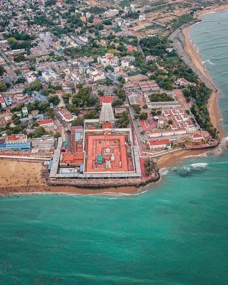 an aerial view of a large building in the middle of the ocean with buildings around it