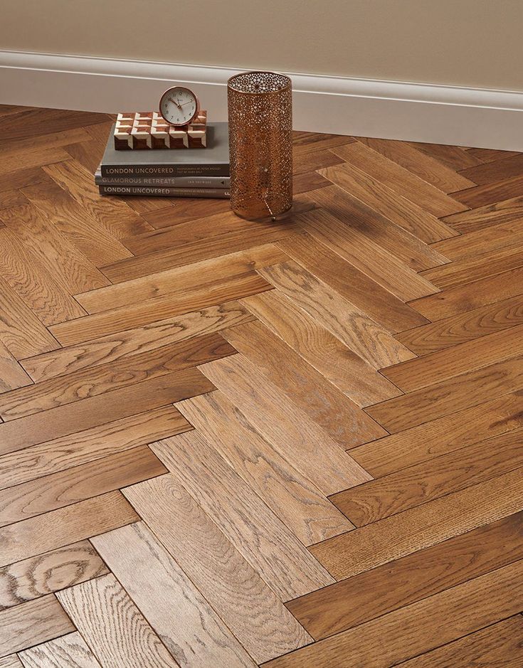 a wooden floor that has some books on top of it and a clock in the corner