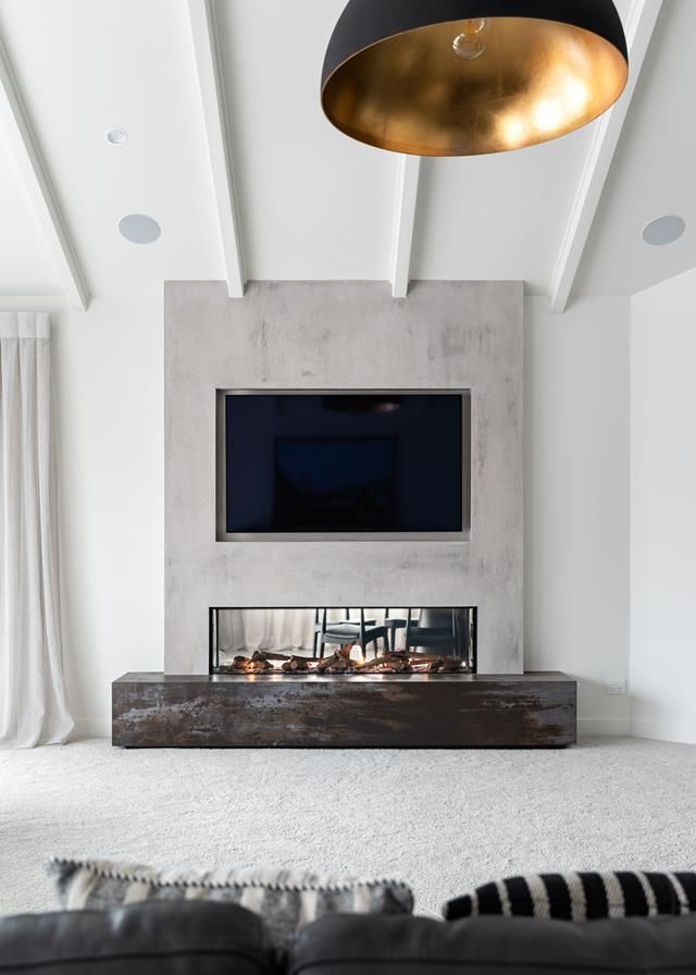 a living room with a large flat screen tv mounted to the wall above a fireplace