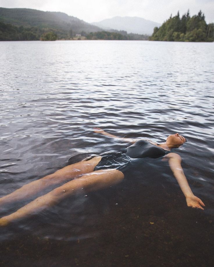 a woman floating on top of a body of water