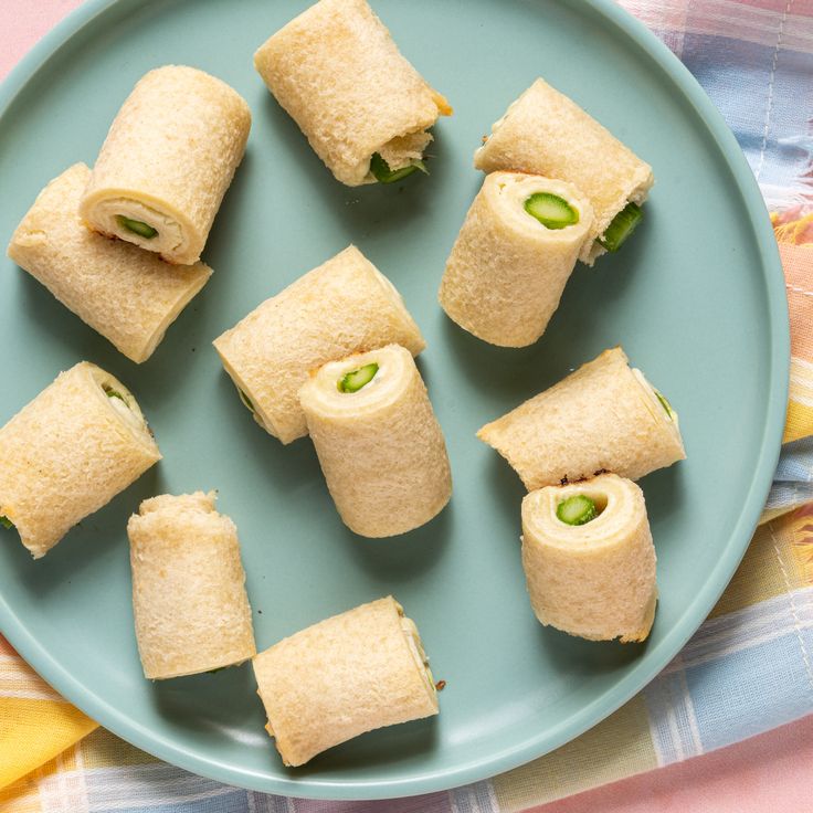 there are several rolls on the plate with cucumber in them and one roll has been cut into smaller pieces