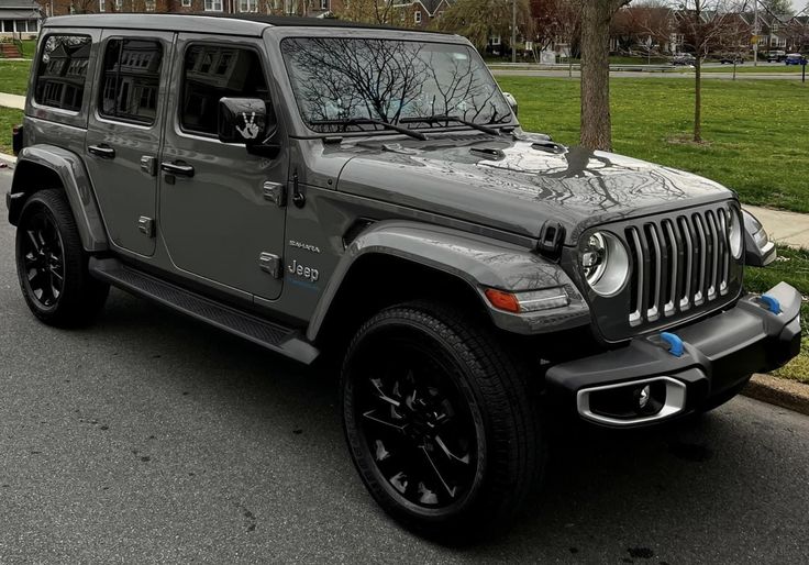 a gray jeep is parked on the side of the road