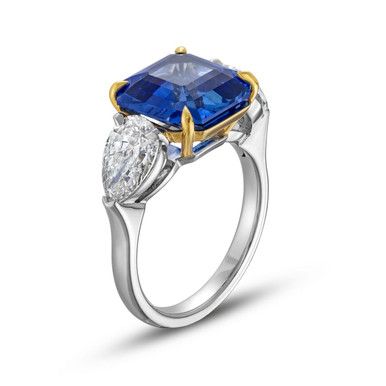 a blue and white ring with two pear shaped diamonds