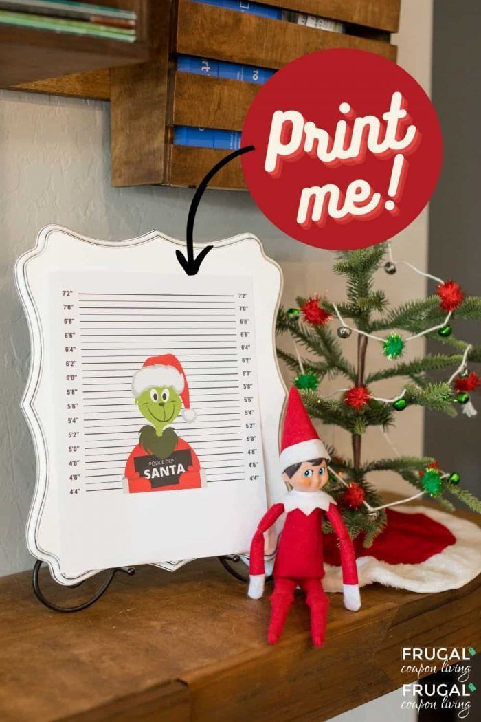 an elf is next to a christmas tree with a print me sign above it and a santa hat on top