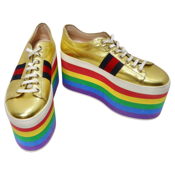 Introducing the Gold Leather Gucci Sneakers with signature navy and red stripes and a playful 3.34" rainbow platform. These sneakers are not just shoes; they're a fashion statement that's both vibrant and fun. Gucci is synonymous with luxury and style, and these sneakers embody the brand's signature look. The classic navy and red Gucci stripes on the sides make a bold and recognizable statement. The gold leather design is a symbol of opulence and elegance. It adds a touch of luxury to your look, making these sneakers perfect for both casual and semi-formal occasions. The 3.34" rainbow platform is a playful and eye-catching detail that sets these sneakers apart. It adds a fun and vibrant touch to your style, making you stand out in the crowd. These sneakers not only look fantastic but also Adidas Platform, Gucci Adidas, Chanel Clutch, Gucci Shop, Versace Dress, Gucci Sneakers, Signature Look, Platform Sneakers, Gold Leather