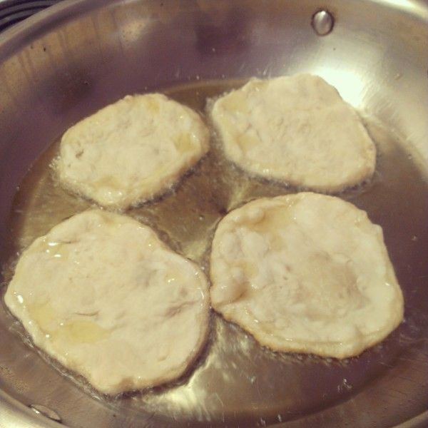 four pieces of meat cooking in a pan