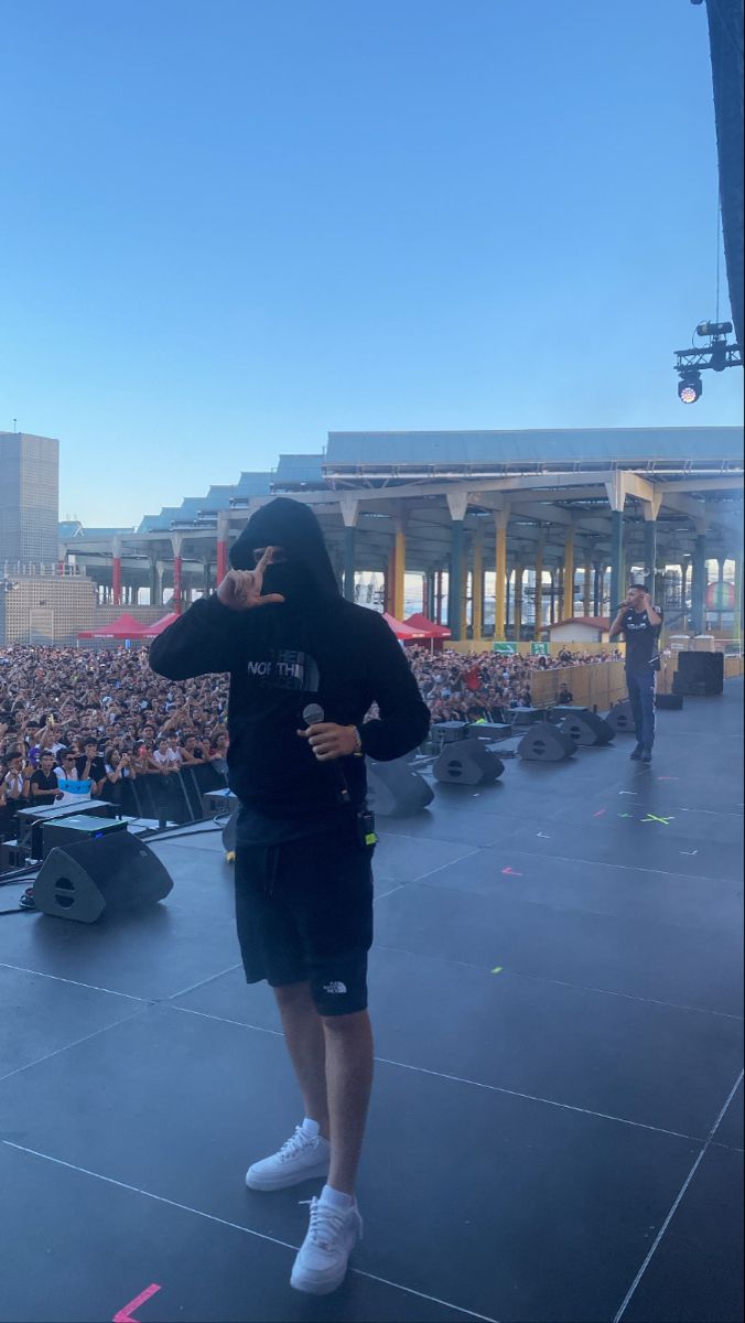 a man standing on top of a stage in front of a large group of people