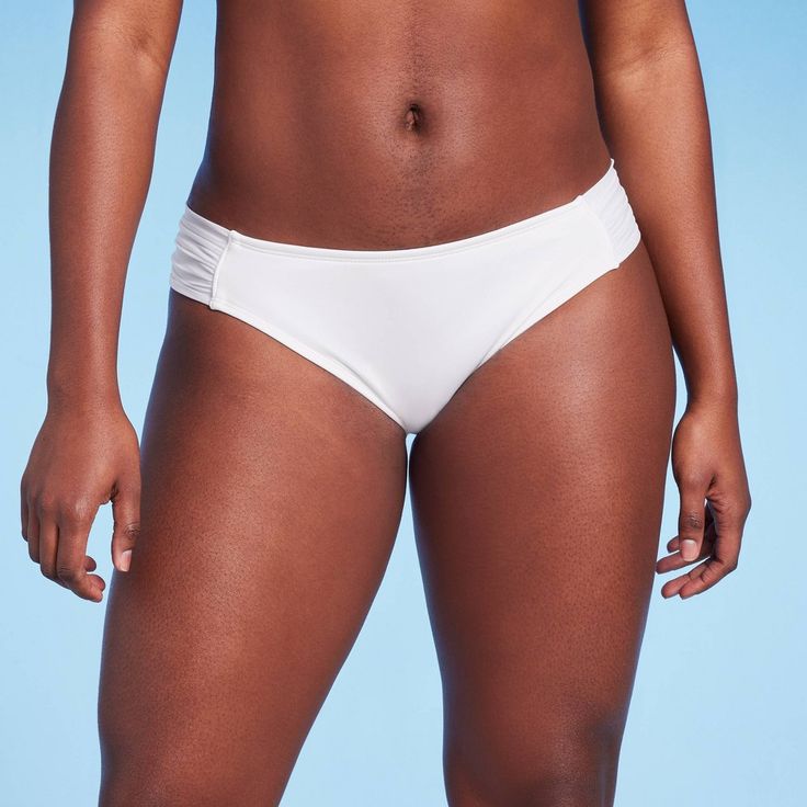 Hit the beach with confidence wearing this Soft Tabside Medium Coverage Bikini Bottom from Kona Sol™. This solid white bikini bottom features a low-rise design with medium-coverage, along with side tab details for chic flair. The stretchy fabric with a touch of spandex keeps you moving comfortably in and out of the water, while the full lining provides confident wear. Pair with a matching bikini top or with other bikini tops for endless styling options. Kona Sol™: Made for your day in the sun. White Stretch Bottoms For Pool, White Stretch Swimming Bottoms, White Tie-side Bottoms For Sunbathing, White Beach Brief Bottoms, White Beach Bottoms In Brief Style, White Brief Swimwear For Vacation, White Beachwear Bottoms For Pool, White Brief Bottoms For Poolside, White Stretch Brief Swimwear