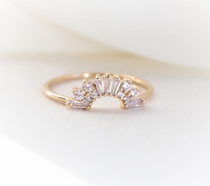 "This elegantly handmade vintage Art Deco-inspired wedding band features a glittering cluster of tapered baguettes and round stones. Before you order the band, please order a home try-on wax model here https://etsy.me/2TRvaLz There will be a 20% restocking fee deducted from your refund in case you need to return the band. So we highly recommend ordering the wax sample to see how it fits with your engagement ring. ❁❁ I T E M ∙ D E T A I L S ❁❁ ✦Stone: Conflict-Free Natural White Diamonds (SI or b Wedding Band Above Engagement Ring, Art Deco Engagement Ring And Wedding Band, Art Deco Band, Vintage Inspired Engagement Rings Art Deco Diamond, Baguette Cut Sparkling Jewelry For Wedding, Sparkling Baguette Cut Jewelry For Wedding, Art Deco Yellow Gold Wedding Rings, Art Deco Wedding Ring With Single Cut Diamonds, Round Engagement Ring With Curved Wedding Band