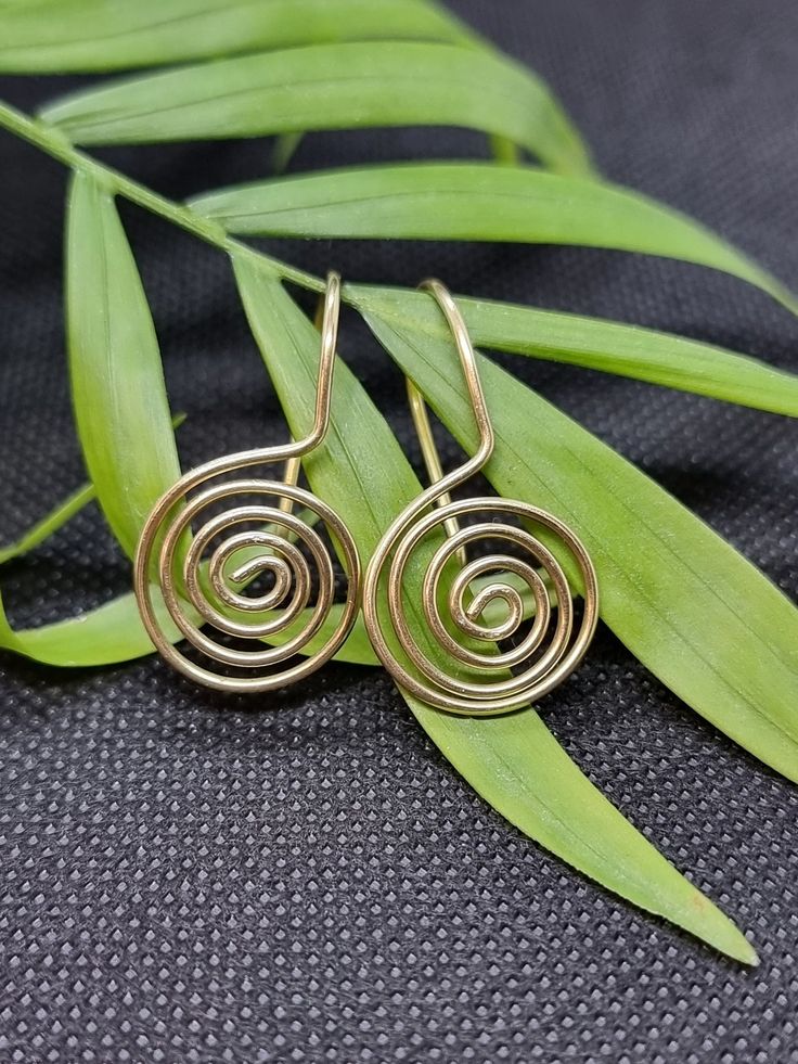 Handmade spiral coiled drop earrings. 25mm drop from lobe. Also available in sterling silver. Spiral Earrings With Ear Wire As Gift, Spiral Earrings With Ear Wire For Gifts, Unique Spiral Earrings For Gift, Minimalist Spiral Jewelry With Matching Earrings, Minimalist Spiral Metal Jewelry, Modern Spiral Earrings With Ear Wire, Handmade Swirl Earrings As Gift, Handmade Swirl Earrings For Gifts, Adjustable Spiral Brass Earrings